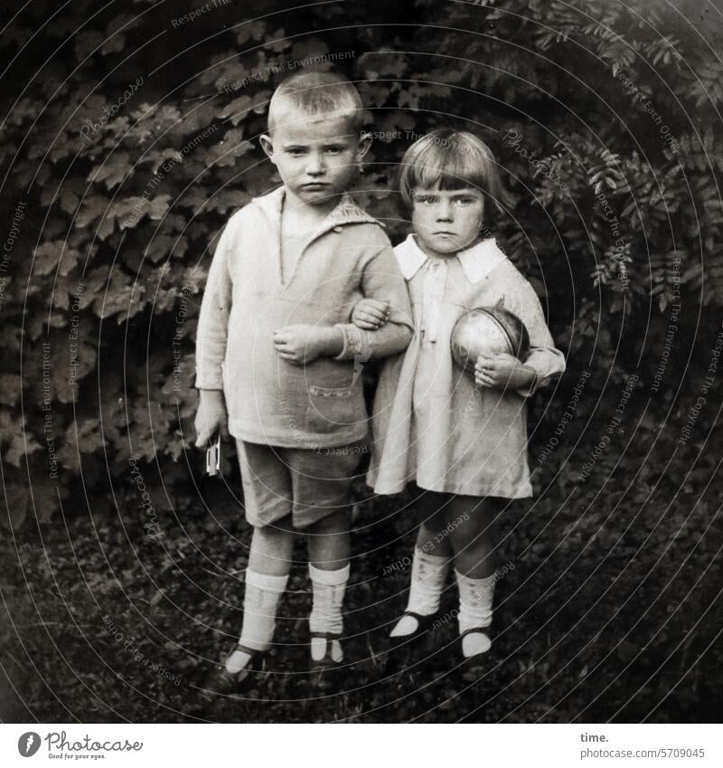 Geschwister mit Spielzeug Junge Mädchen Ball Hecke Garten eingehakt stehen Stimmung ernst Kniestrümpfe damals früher portrait kleidung