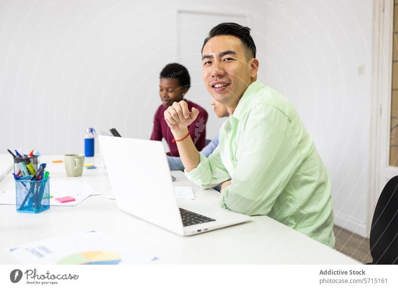 Vielfältiges Team bei einer gemeinsamen Bürobesprechung Sitzung asiatisch Mann Lächeln kollaborativ Arbeit Atmosphäre vielfältig Kollegen lässig Hemd grün