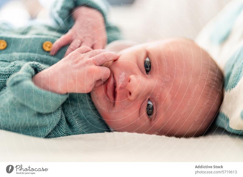 Nahaufnahme eines neugeborenen Babys mit nachdenklichem Gesichtsausdruck, das bequem liegt und die Welt um sich herum betrachtet Ausdruck beschaulich