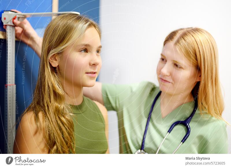Weibliche Ärztin misst die Körpergröße eines Mädchens im Teenageralter. Schulmädchen Patient ist bei Kinderarzt Termin. Gesundheitspflege für Kinder. Arzt
