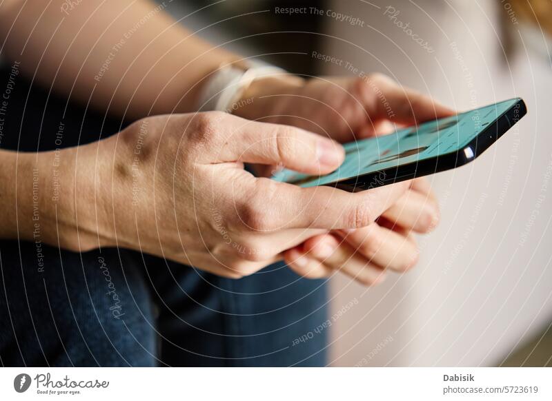 Person beim Surfen in sozialen Medien auf dem Smartphone in Innenräumen soziale Netzwerke Browsen benutzend Hände Bildschirm digital heimwärts Inhalt