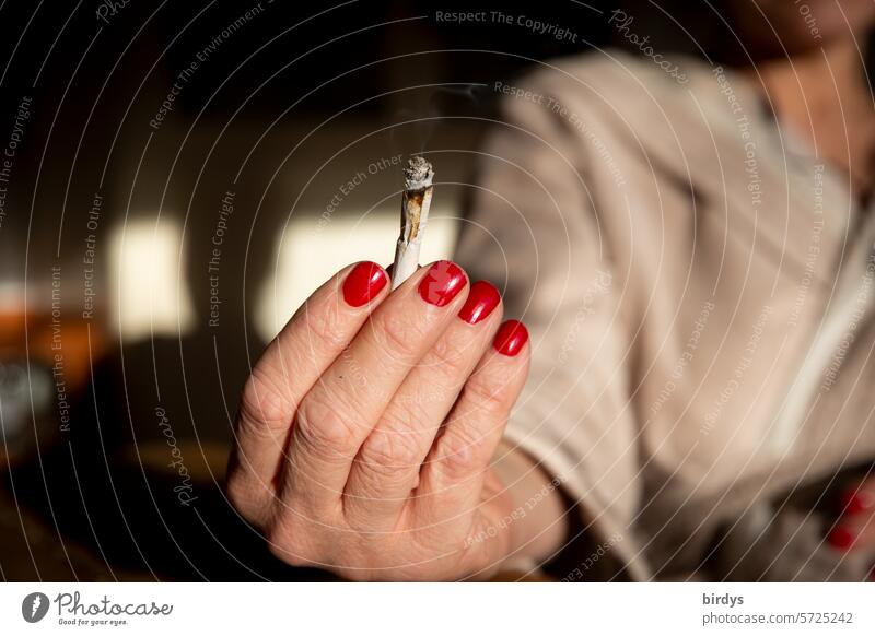 Frau bietet einen Joint an Cannabiskonsum anbieten rauchen Hand Nagellack lackierte fingernägel weiterreichen weitergeben kiffen Rauschmittel Rauchen Frauenhand