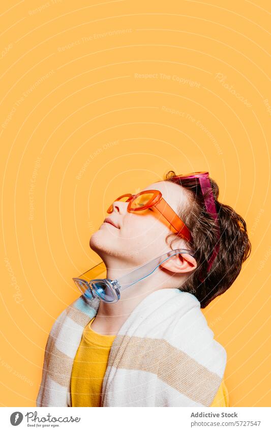 Jugendlicher Geist mit bunter Sonnenbrille und Kopfhörer Kind Junge pulsierend einzeln orange Hintergrund Stil Mode Farbe Accessoire zuhören Musik modern lässig