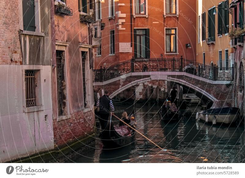 Blick auf einen venezianischen Kanal zwischen roten Backsteinhäusern mit einer fahrenden Gondel Venedig Venedig-Kanal roter Backstein roter Backsteinbau Häuser
