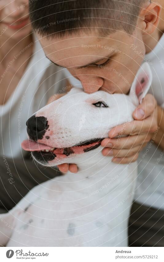 junges Paar Kerl und Mädchen in einem hellen Raum spielen mit Haustier Baustein braun Eckstoß Hund Ohren Freund grau Typ Licht Männerfreund Nase rosa sanft