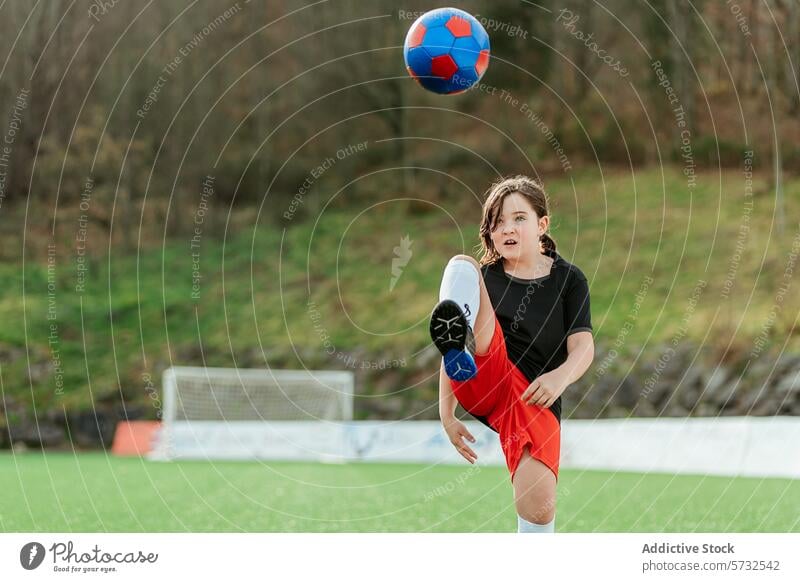 Junger Fußballspieler, der den Ball auf dem Feld kickt Spieler Mädchen jung Sport tretend Tatkraft Jugend grasbewachsen im Freien Aktivität sportlich Kind