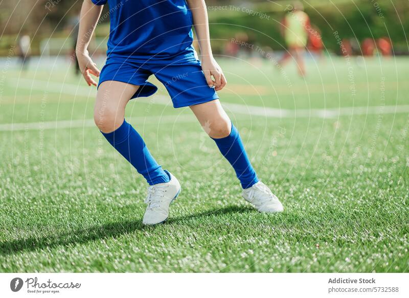 Nahaufnahme der Beine eines Fußballspielers auf dem Spielfeld Spieler Sport Feld Gras blau Uniform Fußballer Detailaufnahme grasbewachsen im Freien sportlich