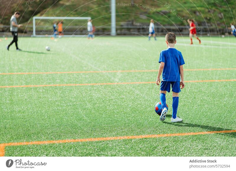 Junger Fußballspieler auf dem Feld während eines Spiels Spieler jung Athlet Uniform blau grün Team Sport Jugend Streichholz Konkurrenz spielen im Freien Gras