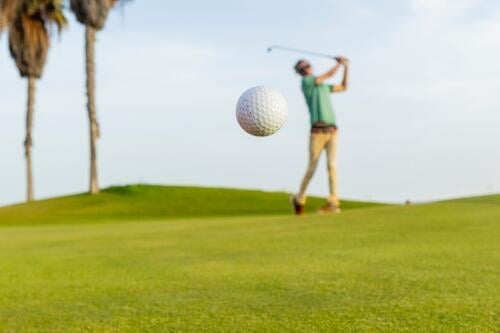 Anonymer Golfer beim Spielen an einem sonnigen Tag pendeln Kurs grün Himmel übersichtlich Bewegung Sport aktiv Freizeit im Freien Palme Hobby spielen Ball