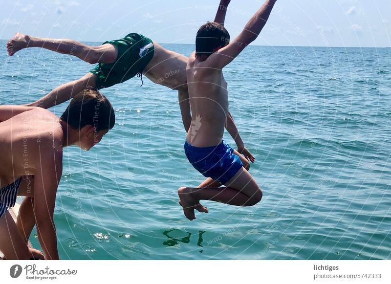 Sprungchance - Drei Jungs springen  freudig wild direkt ins Meer sommer sprung wasser meer warm sonne abkühlung kopfsprung freude