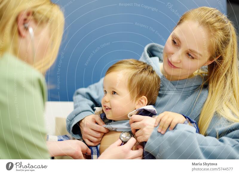 Ein süßes Kleinkind hat einen Termin bei einem fürsorglichen Kinderarzt. Der Arzt hört den Herzschlag und die Atmung des kleinen Patienten mit einem Stethoskop ab