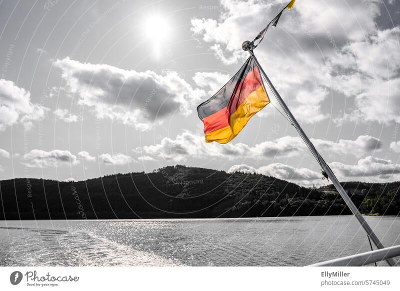 Bunte Deutschlandfahne vor schwarz weißem Hintergrund Fahne Deutsche Flagge Nationalflagge Wind wehen Deutschlandflagge Nationalitäten u. Ethnien