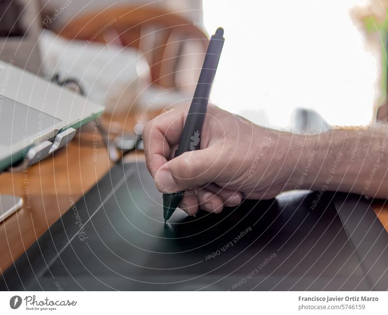 Hand eines Mannes, der mit einem digitalen Stift auf einem Grafiktablett zeichnet Tablette Technik & Technologie Computer Designer graphisch Arbeit zeichnen