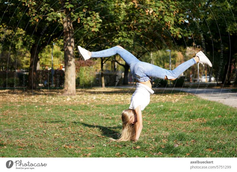 Mädchen übt Handstand in einem Park Natur Frau Lifestyle Spaß Übung im Freien Aktivität sorgenfrei Vitalität Kunstturnen Sport Fitness jung Turner Spontaneität