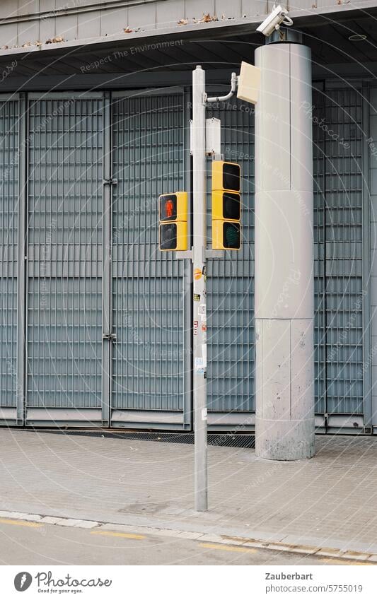 Ampel steht vor grauem Tor, Betonsäule, modern und karg Anpel Fußgängerampel Säule trist Politik Stillstand halt ampelmännchen Verkehrszeichen