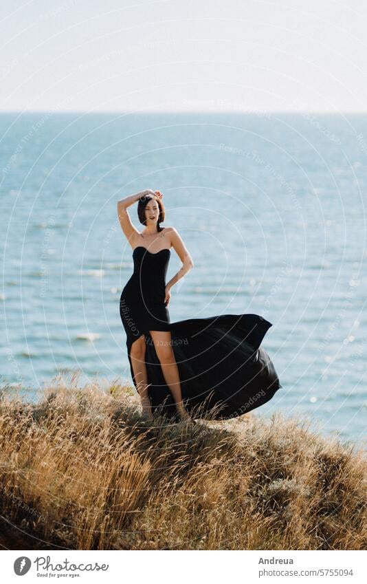 Großes Mädchen Modell in einem schwarzen Kleid auf den Berghügeln hoch Hügel Berge u. Gebirge MEER von oben Sommer blau Himmel Gras grün gelb Ton