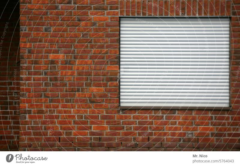 heruntergelassen Rollo Fenster Fassade geschlossen Haus Gebäude trist Rolladen Architektur Wand Häusliches Leben Backstein abschottung wohngebäude klinker