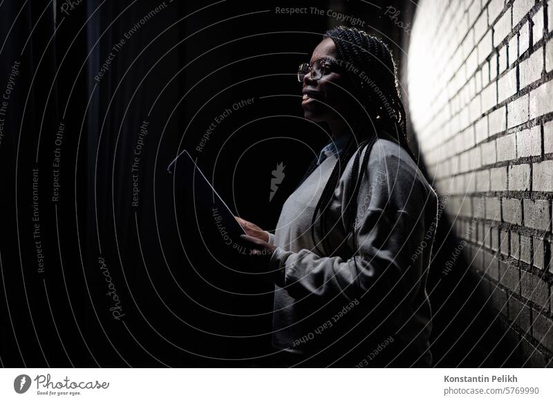 Minimal Seitenansicht Porträt der schwarzen jungen Frau proben auf der Bühne im Theater mit wenig Licht Kopie Raum Künstler Künstlerin Schauspieler