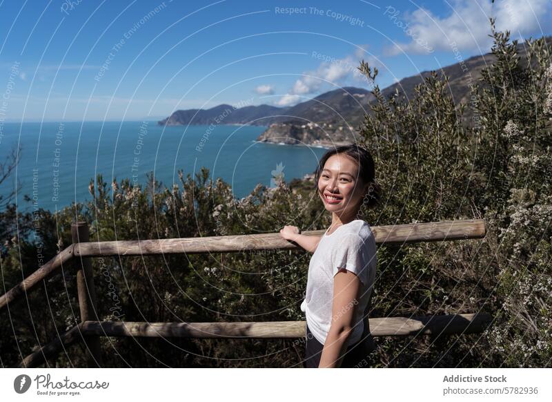 Lächelnde junge Frau genießt die Aussicht auf die italienische Küste reisen Italien malerisch Ansicht italienische Riviera Blauer Himmel Seeküste Tourismus