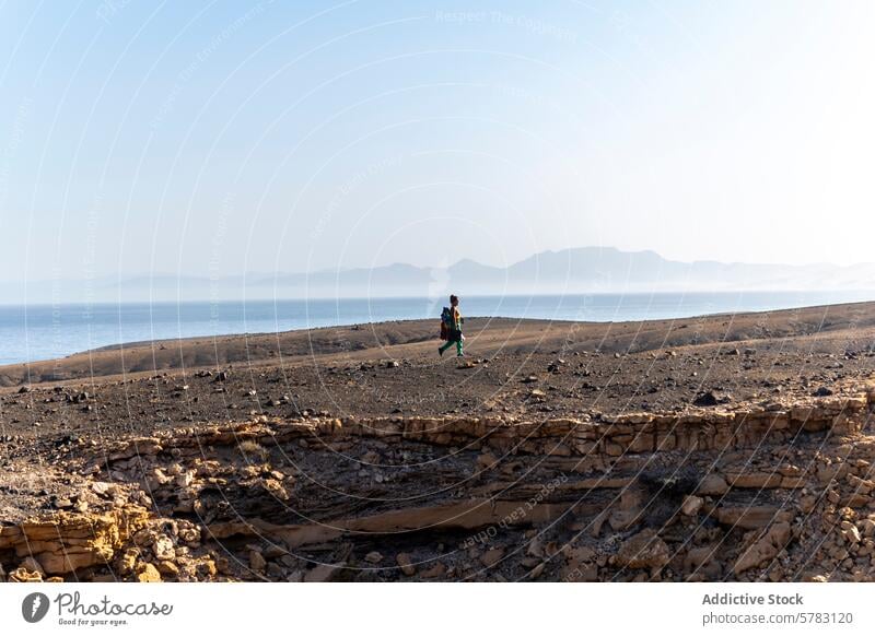 Wanderer erkundet Fuerteventuras raues Terrain wandern Frau Camping Kanarische Insel Spanien Meer Berge u. Gebirge Landschaft trocken Gelände reisen Abenteuer