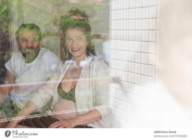 Ein Ehepaar genießt einen gemütlichen Moment zu Hause Paar heimwärts Fenster Lachen bequem Einstellung Glück Teilen im Innenbereich heimisch Leben Freizeit