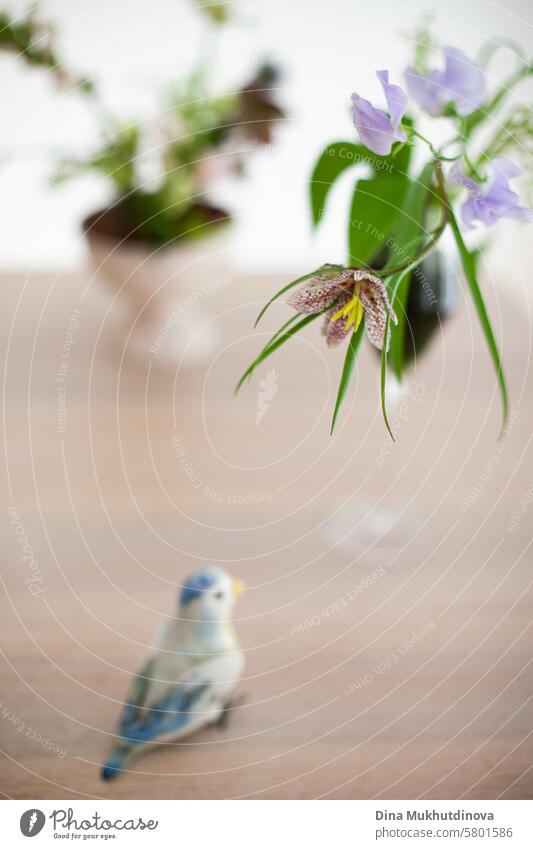 Fritillaria meleagris Frühling Blume Nahaufnahme auf weißem Hintergrund ästhetische florale Bild in Glas und Keramik Vogel-Figurine Blumen purpur Fliederbusch