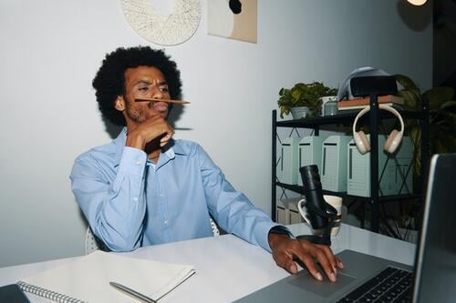 Bored office manager playing with pencil instead of working fun bored funny Black man businessman online communication laptop portrait computer desk workplace