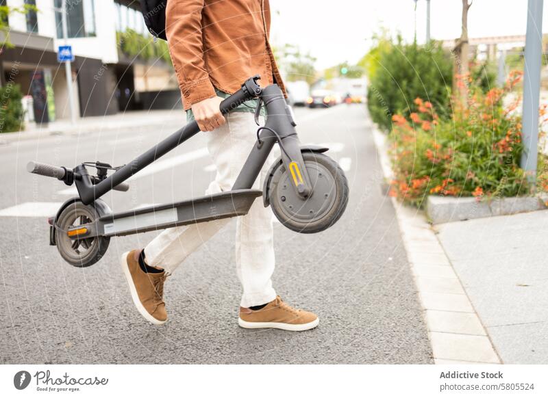 Mann mit einem Elektroroller auf einer Straße in der Stadt Großstadt Verkehr urban Bürgersteig lässig Kleidung praktisch tragen modern Grün Umschalttaste Umwelt