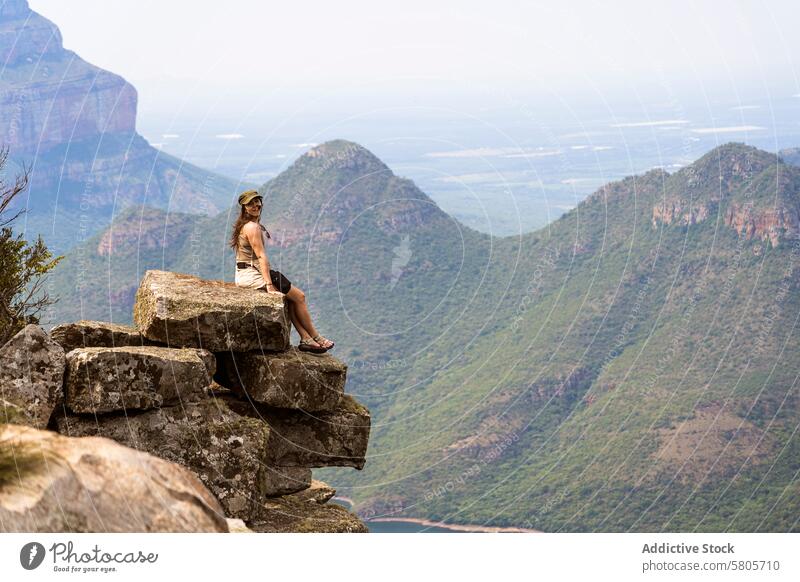 Gelassener Blick auf die Berge mit einer Reisenden Frau Sitzen Felsen Berge u. Gebirge Landschaft übersehen Gelassenheit reisen Natur im Freien Abenteuer