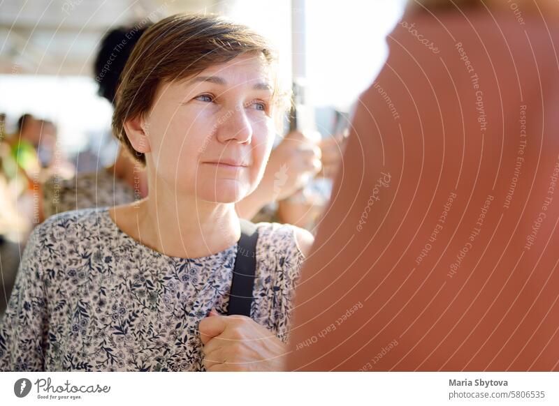 Reife Frau Tourist bewundert Blick auf das Goldene Horn Meeresfront von Tour Boot bei Sonnenuntergang. Reisen und Tourismus in Istanbul, Türkei. reif Truthahn