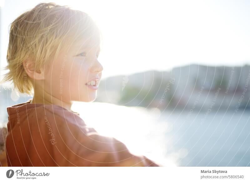 Cute blonde preteen Junge reist mit dem Boot oder Fähre auf dem Meer. Familienurlaub am Ozean oder Meer. Sommerfreizeit für Familien mit Kindern. MEER Feiertag