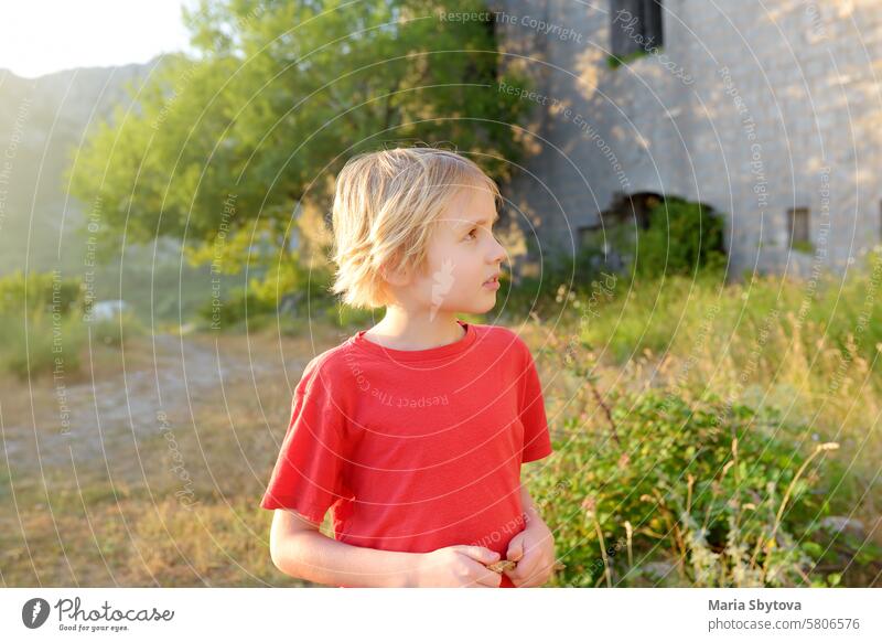 Ein Junge im Vorschulalter besucht die Festung Kosmach in Montenegro. Die Festung befindet sich in der Nähe von Budva. Die alte Burg wurde in der österreichisch-ungarischen Monarchie als Verteidigungsanlage und Beobachtungsposten gebaut.