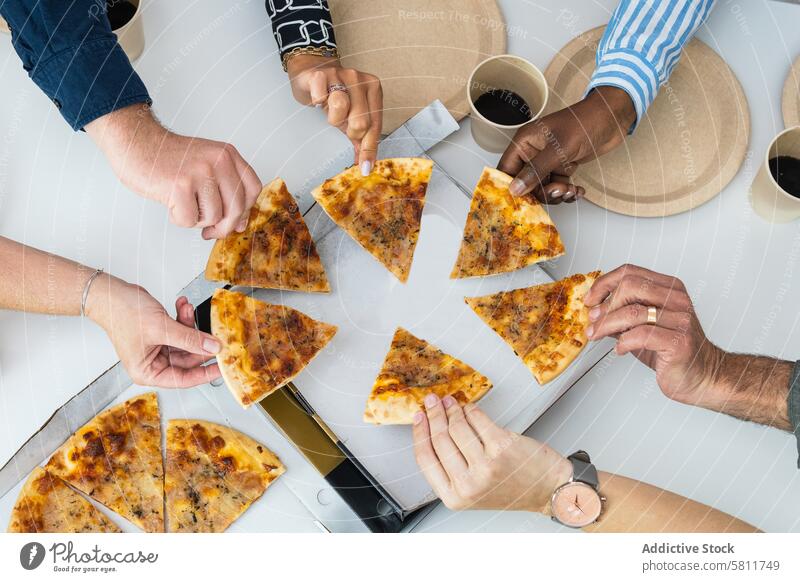 Crop diverse Freunde essen Pizza während des Treffens Sitzung Tisch Unternehmen sich[Akk] sammeln Tablette Spielfigur Menschengruppe Freundschaft multiethnisch