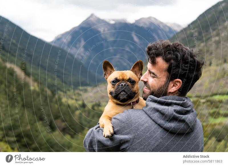 Glücklich reisender Mann umarmt süßen Hund im Hochland Berge u. Gebirge Kuss Zusammensein Umarmen Reisender Wanderer männlich Pyrenäen französische Bulldogge