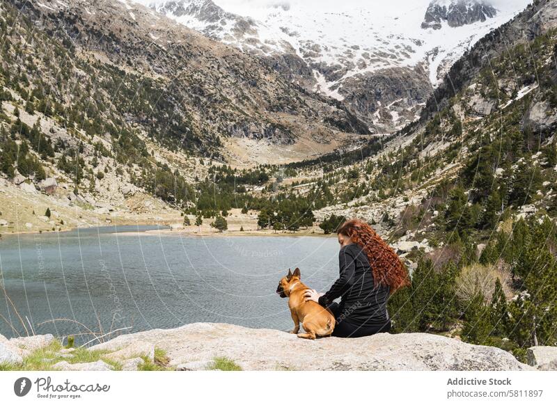 Reisende Frau mit Hund in den Bergen Reisender Berge u. Gebirge See Aussichtspunkt reisen Haustier Hochland Teich Pyrenäen Zusammensein bewundern Eckzahn Stein
