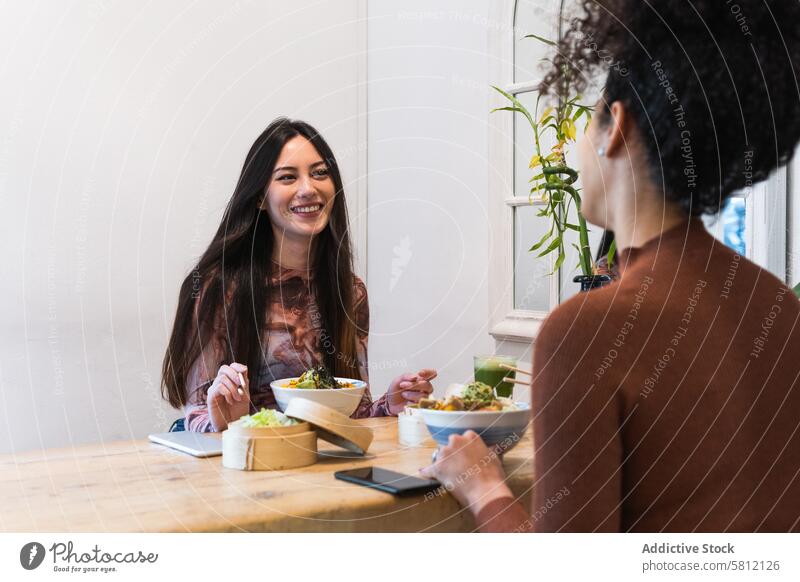 Zufriedene freundliche multiethnische Frauen beim Essen im Restaurant Freund essen Kälte stoßen Speise geschmackvoll Freundschaft Zusammensein vielfältig