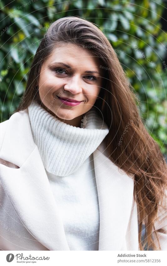 Glückliche stilvolle Frau mit weißem Pullover, die sich im Park ausruht Stil Lächeln elegant trendy genießen Mode charmant Erwachsener brünett lange Haare