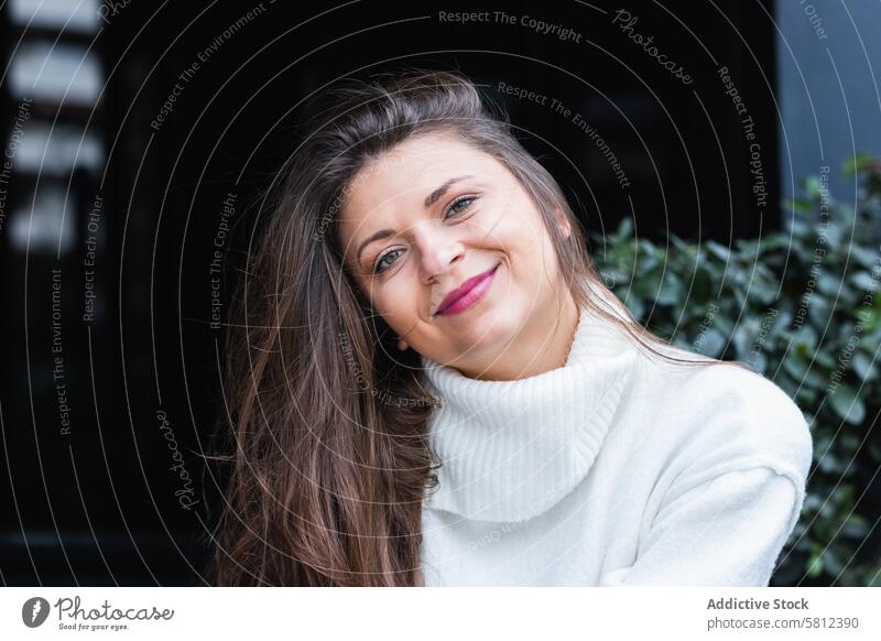 Glückliche stilvolle Frau mit weißem Pullover, die sich im Park ausruht Stil Lächeln elegant trendy genießen Mode charmant Erwachsener brünett lange Haare