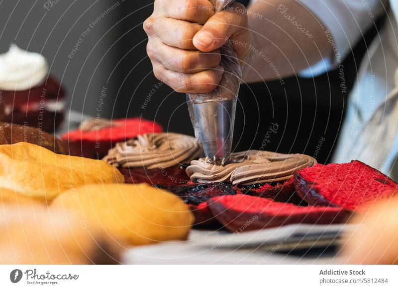 Unbekannter Bäcker, der in der Küche Sahne auf Torten gibt Kuchen Koch Dessert Backwarenbeutel Gebäck Veganer Schwamm Bäckerei Schokolade lecker kulinarisch