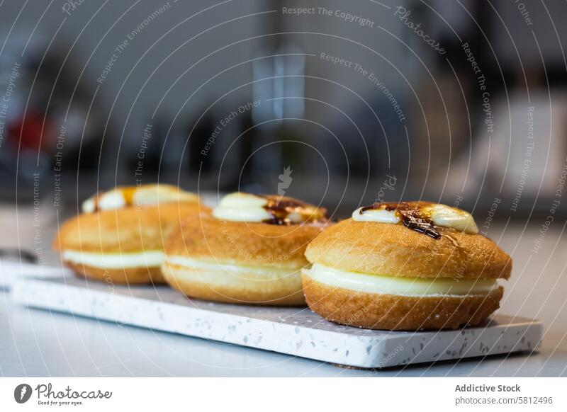 Kropfenkoch mit appetitlichen Berlinern auf einem Tablett in einer Bäckerei berliner Dessert Veganer süß Kruste Sahne Holzplatte Lebensmittel kulinarisch
