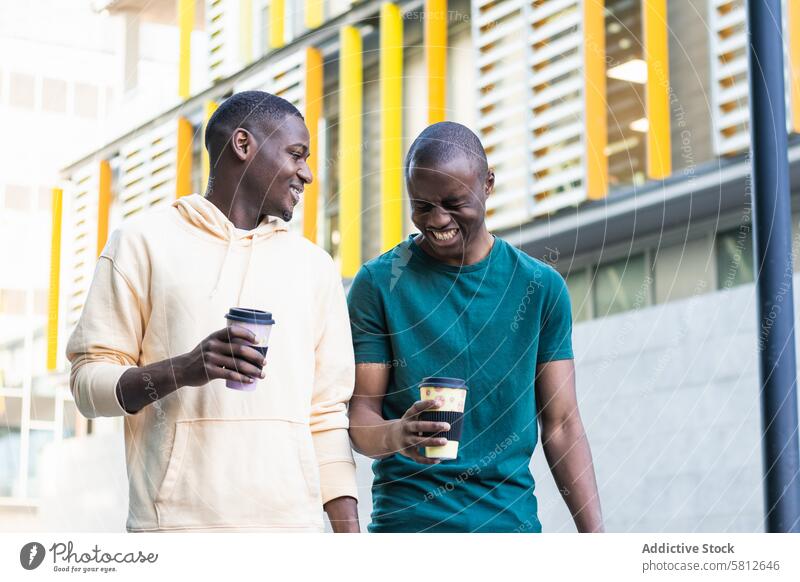 Glückliche beste schwarze Freunde lachend mit Kaffee zum Mitnehmen auf der Straße bester Freund Lachen freie Zeit Wochenende Freundschaft interagieren Männer