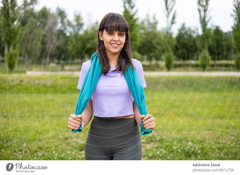 Sportliche Frau mit einem Handtuch für das Fitnesstraining im Freien aktiv Sportkleidung Erwachsener Athlet Körper Kaukasier Nahaufnahme Selbstvertrauen