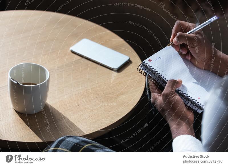 Trendiger junger Schwarzer bei der Arbeit in einem Café Mann zur Kenntnis nehmen Prüfungsvorbereitung selbstbewusst Stil klug Mode Kaffee Anweisung Bildung