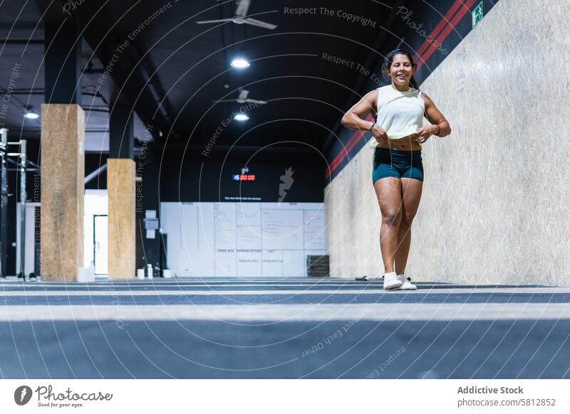 Positive hispanische Sportlerin beim Laufen im Fitnessstudio Frau Training Gesunder Lebensstil Wellness muskulös sportlich Dame selbstbewusst positiv froh