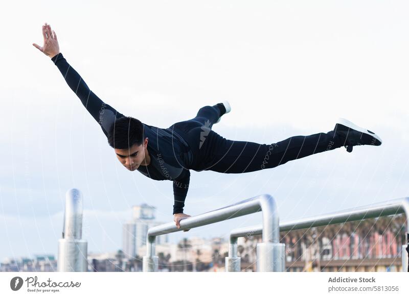 Sportlerin bei einer Übung am Barren Turner Handstand Training Athlet Gleichgewicht Fitness jung Mann asiatisch ethnisch Sportpark gymnastisch physisch Ausdauer