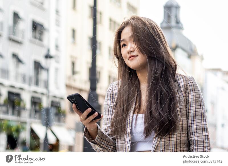 Junge asiatische Frau beim Spazierengehen und mit Smartphone in der Stadt Menschen Straße Großstadt jung Glück Lifestyle laufen Spaß im Freien Frauen urban