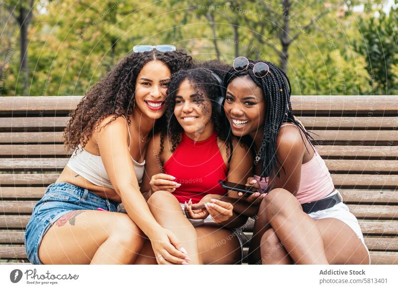Afroamerikanische Freunde genießen den Sommer gemeinsam und nutzen das Smartphone Afroamerikaner Vielfalt Jugend Mitteilung Freude lachen Fröhlichkeit Freizeit