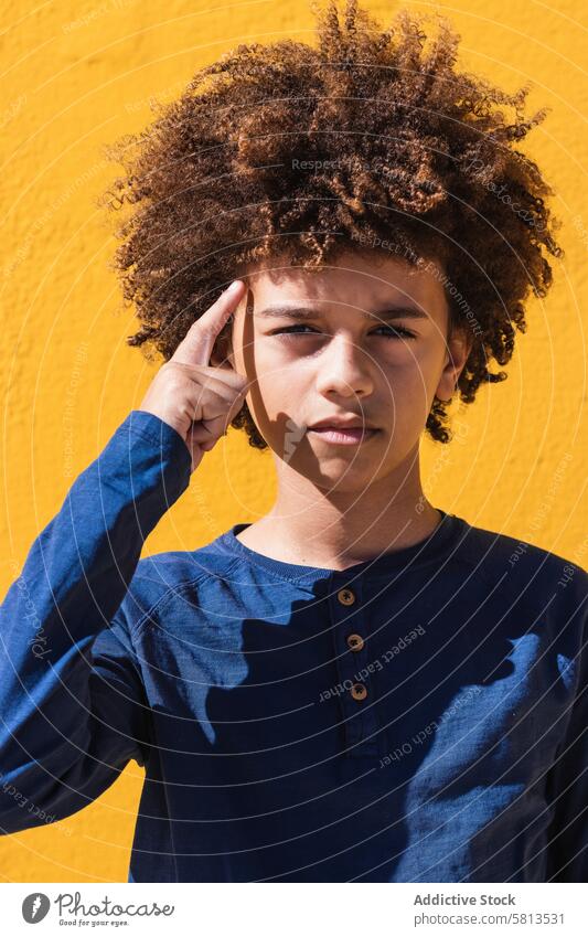 Nachdenklicher ethnischer Junge mit Afrofrisur Kind Afro-Look krause Haare besinnlich nachdenklich Teenager Frisur Denken Porträt farbenfroh Behaarung männlich