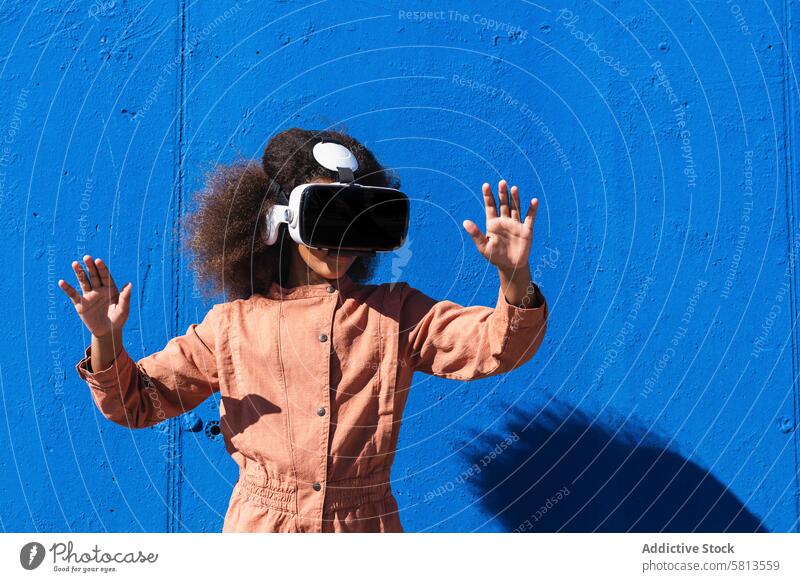 Ethnischer Teenager im VR-Headset erkundet den Cyberspace Kind Virtuelle Realität erkunden Mädchen Gerät benutzend Schutzbrille Frau Afroamerikaner Afro-Look