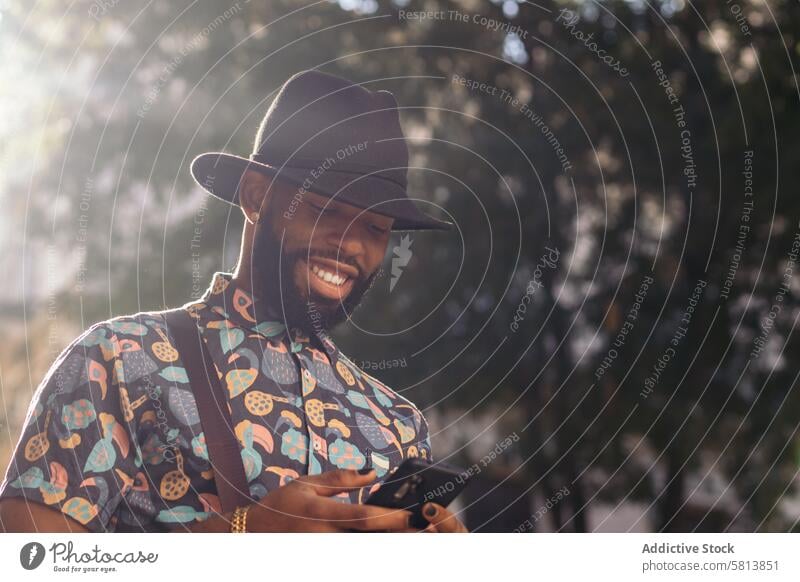 Stilvoller schwarzer Mann auf der Straße mit Smartphone Technik & Technologie Lifestyle Großstadt jung urban Telefon Mobile männlich Person benutzend